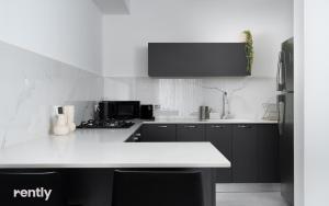 a kitchen with black cabinets and a white counter top at neve tzedek luxury family apartment by rently in Eilat