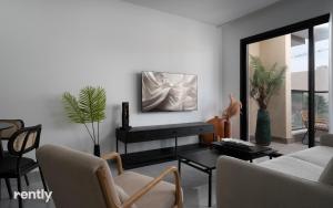 a living room with a tv on a wall at neve tzedek luxury family apartment by rently in Eilat