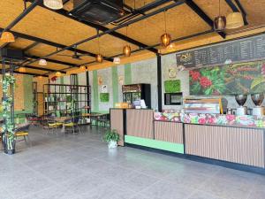 a restaurant with a counter and tables and chairs at Chom Nakhon Resort in Tha Sala