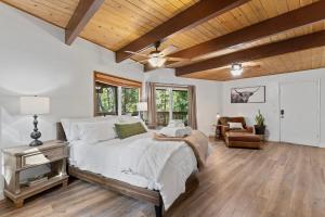 ein Schlafzimmer mit einem Bett und einer Holzdecke in der Unterkunft Cozy Owl Lodge, Central AC & Hea, Spa Tub & BBQ in Lake Arrowhead