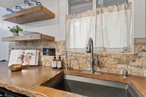 eine Küchentheke mit Spüle und Fenster in der Unterkunft Cozy Owl Lodge, Central AC & Hea, Spa Tub & BBQ in Lake Arrowhead + 42 Fotos