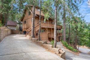 ein großes Holzhaus mit Auffahrt in der Unterkunft Cozy Owl Lodge, Central AC & Hea, Spa Tub & BBQ in Lake Arrowhead