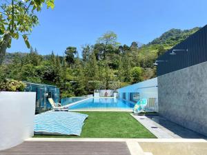 a backyard with a swimming pool and grass at Fantasea Condo - Kamala in Kamala Beach