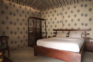 KālwāraChandraprabha Signature Resort Jaipur的壁纸客房内的一间卧室配有一张床