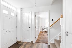 a white hallway with white doors and a table at Home away from Home French luxury in Birmingham in Birmingham