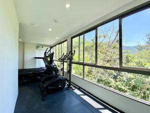 a fitness room with a gym with windows at Fantasea Condo - Kamala in Kamala Beach