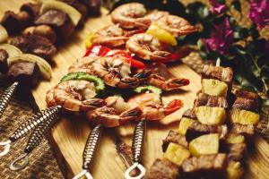 a wooden cutting board with shrimp and other foods at ANA InterContinental Manza Beach Resort by IHG in Onna