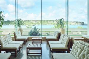 a room with chairs and tables and a large window at ANA InterContinental Manza Beach Resort by IHG in Onna