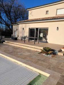 a patio with a table and a bench next to a house at Studio près du golf in Montauban +4 photos