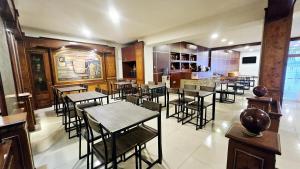 a restaurant with tables and chairs in a room at New Tiga Intan Hotel in Bandung