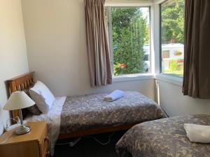 a hotel room with two beds and a window at Private Rooms with Shared Bathroom in Lake Tekapo