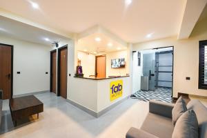 グルガオンにあるFabHotel RR Premium - Near Medanta Hospitalのソファとカウンターのあるリビングルーム