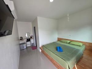 a bedroom with a bed with blue pillows on it at ต้นหว้ารีสอร์ท Tonwa resort in Chao Lao Beach