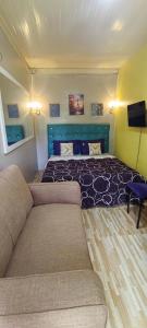 a bedroom with a large bed and a couch at Kikay's Bed & Breakfast in Tagaytay