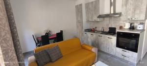 a living room with a yellow couch in a kitchen at One bedroom TEA apartment Il-Gzira in Il-Gżira