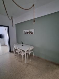 un tavolo bianco con sedie in una stanza bianca di athens.apartotel.2 ad Atene