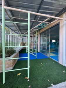 un bâtiment vide avec une salle de sport dotée d'un sol vert dans l'établissement Villa Chamnan, à Choeng Mon Beach