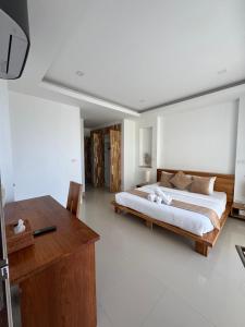 une chambre avec un grand lit et un bureau dans l'établissement Villa Chamnan, à Choeng Mon Beach 13 autres photos