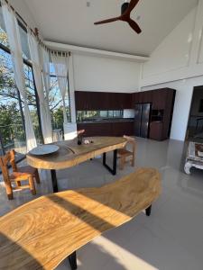 une cuisine avec des tables et des bancs en bois dans une pièce dans l'établissement Villa Chamnan, à Choeng Mon Beach