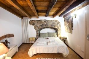 a bedroom with a large bed with a stone wall at Porta Dipinta House Bergamo Alta in Bergamo
