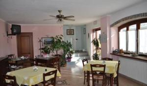 a dining room with tables and chairs and a ceiling fan at Agriturismo Ai Piacentini in Santo Stefano Belbo