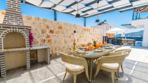 een eetkamer met een tafel en stoelen en een bakstenen muur bij Luxury Apartment in Kalkan - 7522 in Kalkan