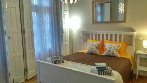 um quarto com uma cama e um espelho na parede em Trindade Apartment em Porto