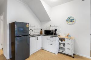a kitchen with a stainless steel refrigerator and white cabinets at Pearl of Scarborough in Scarborough