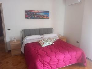 a bedroom with a bed with a pink blanket at Manfredi Apartments in Torre Annunziata