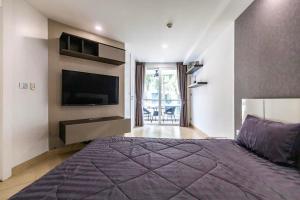 a bedroom with a large bed and a flat screen tv at Large luxury condo - Pattaya City Centre - Centara Avenue, Pool View - 217 in Pattaya Central +11 photos