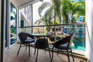 a balcony with a table and chairs and a view of a pool at Large luxury condo - Pattaya City Centre - Centara Avenue, Pool View - 217 in Pattaya Central