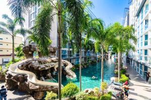 a water slide at a resort with palm trees at Large luxury condo - Pattaya City Centre - Centara Avenue, Pool View - 217 in Pattaya Central