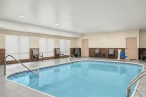 a pool in a hotel room with chairs and tables at Fairfield Inn & Suites Mt. Pleasant in Mount Pleasant