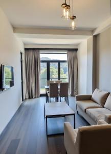 a living room with a couch and a table at Tsaghkadzor Kechi Heights Retreat - Luxe Family Apartment in Tsaghkadzor