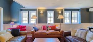 a living room with two couches and windows at nakano museum HOTEL in Hokuto