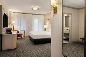 a hotel room with a bed and a mirror at The Talbott, Autograph Collection in Chicago +75 photos