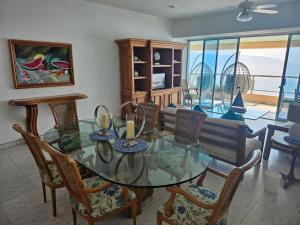 a dining room with a glass table and chairs at Tropical Paradise Getaway in Acapulco with Private Infinity Pool in Acapulco +3 photos