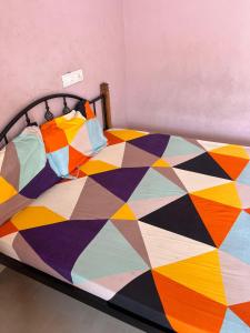 a bed with a colorful quilt on it at KRN Residency in Nagari