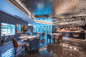 広州市にあるCityNote Hotel -Guangzhou Beijing Road Pedestrian Street Yuexiu Park Branchのテーブルと椅子とバーのあるレストラン