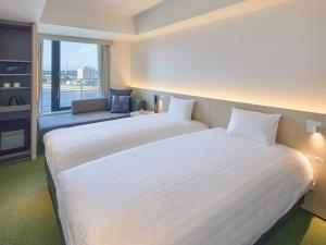 堺市Dorsett by Agora Osaka Sakai的带窗户的房间里有一张白色的大床