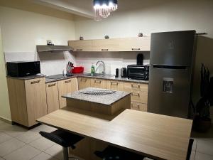 Una cocina con un refrigerador y una mesa dentro. en Cosy and modern flat in Mauritius, en Flic en Flac