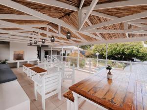 a living room with a wooden table and white chairs at Wildecrest & Ripplemead, Amblewood Guesthouse in Kenton on Sea