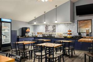 a restaurant with tables and chairs and a kitchen at AmericInn by Wyndham Lincoln South in Lincoln