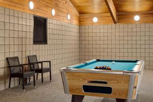 a room with a pool table and two chairs at AmericInn by Wyndham Lincoln South in Lincoln