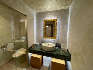 ein Badezimmer mit Waschbecken und Spiegel an der Wand in der Unterkunft hotel evi tower 大人専用 in Toda