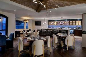 佩索罗伯斯Bellasera Hotel & Suites Paso Robles, Tapestry by Hilton的有桌椅和酒吧的餐厅