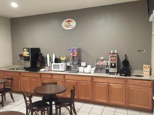 a restaurant with a counter with a table and chairs at Super 8 by Wyndham Bastrop TX in Bastrop