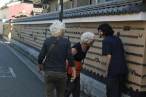 a group of three people standing next to a wall at hanare in Tokyo