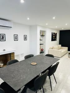 a dining room with a table and chairs and a couch at Villa avec Spa & Sauna, Évasion in Béziers