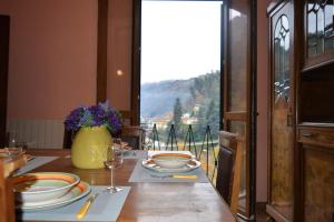 a table with plates and glasses on a table with a view at Bellavista apartment in Bagni di Lucca